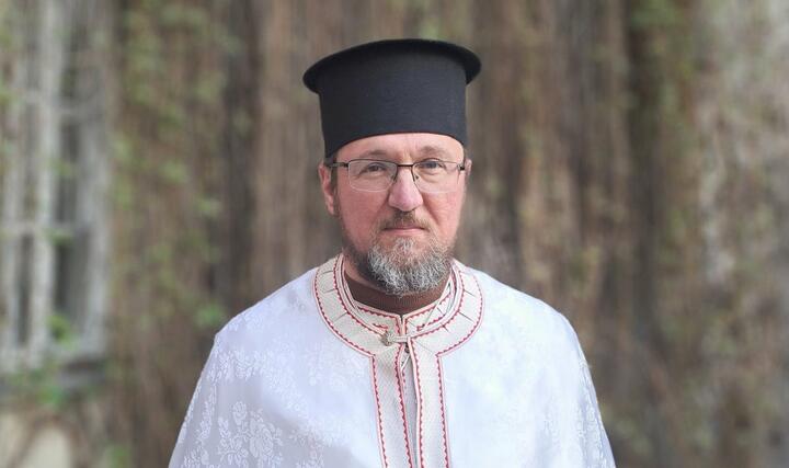 православный священник Георгий Рой в белом костюме