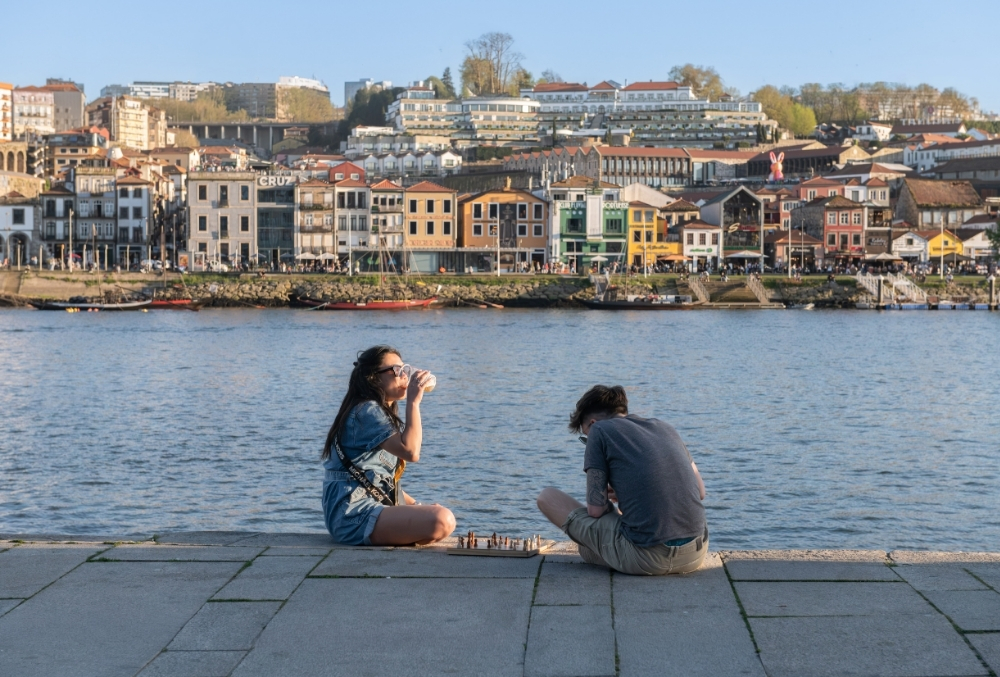 Мужчина и женщина сидят у воды и играют в шахматы — спокойный момент без спешки в Португалии